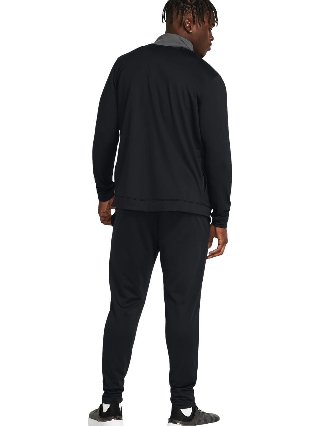 Conjunto deportivo Under Armour en color negro con detalles grises en los hombros.