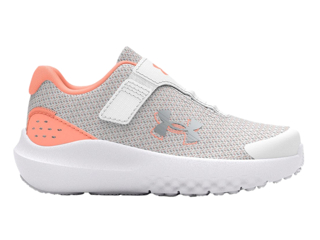 Tenis deportivos Under Armour color gris con suela blanca y detalles en naranja.