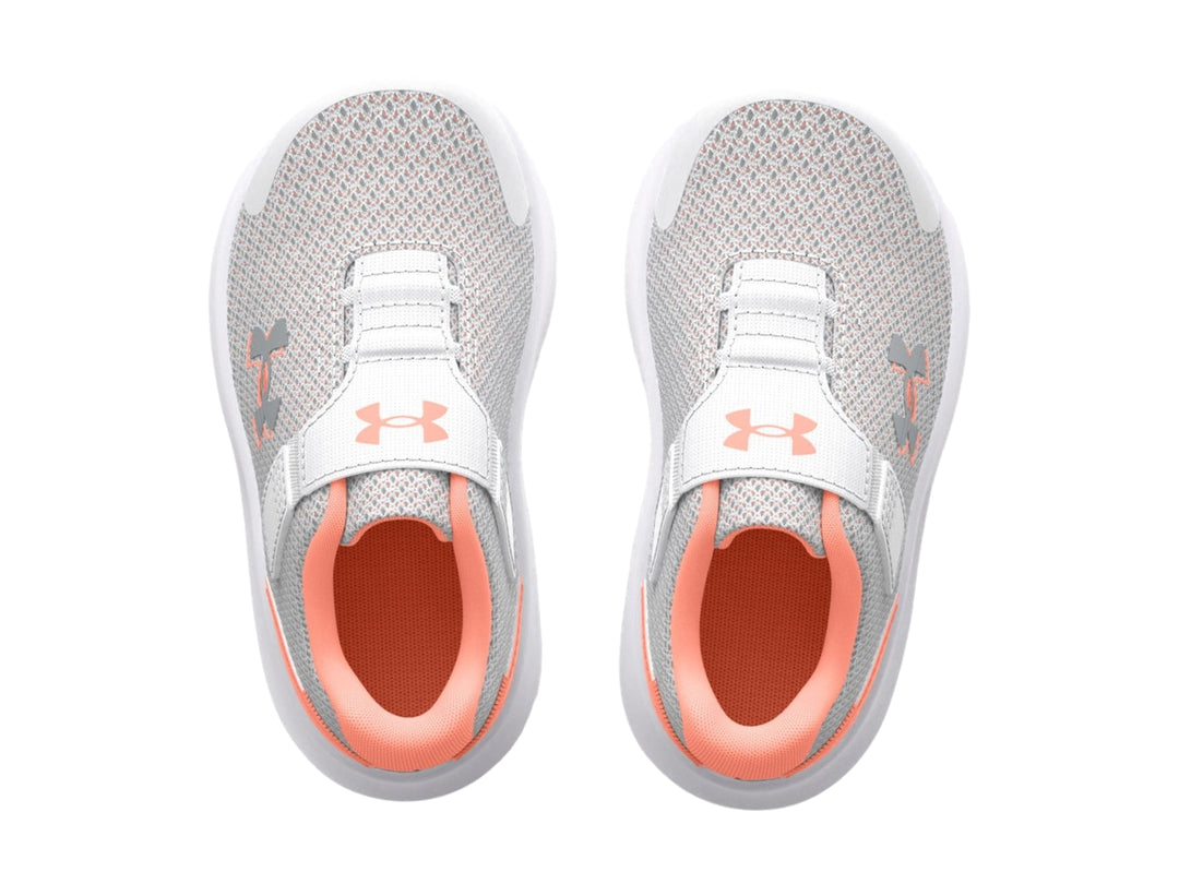 Tenis deportivos Under Armour color gris con suela blanca y detalles en naranja.