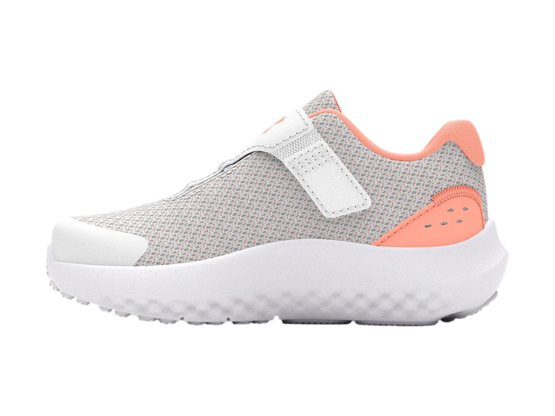 Tenis deportivos Under Armour color gris con suela blanca y detalles en naranja.