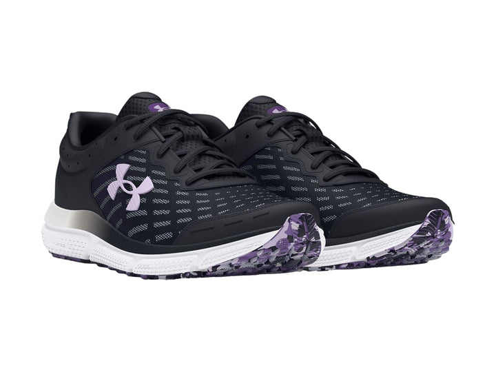Tenis deportivos Under Armour color negro con suela blanca y detalles en morado.