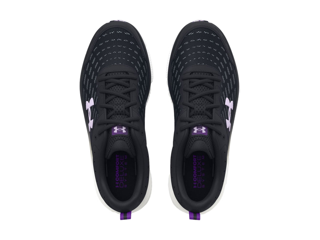 Tenis deportivos Under Armour color negro con suela blanca y detalles en morado.