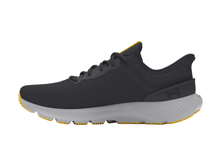 Tenis deportivos Under Armour color gris con suela clara y detalles en amarillo.