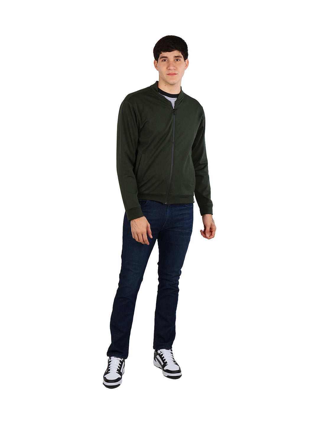 Hombre vistiendo una chamarra bomber color verde militar con cierre frontal y pantalones azul marino.