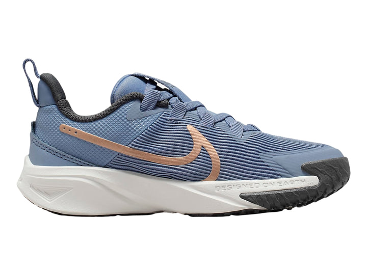 Tenis deportivos Nike Star Runner 4 en color azul con suela blanca y detalles en bronce.