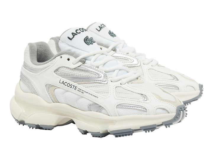 Tenis deportivos Lacoste color blanco y gris con suela gruesa y detalles plateados.