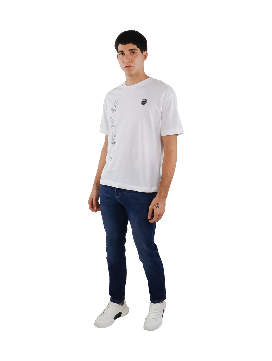 Hombre vistiendo playera blanca de manga corta K-Swiss con estampados laterales y logo en el pecho.
