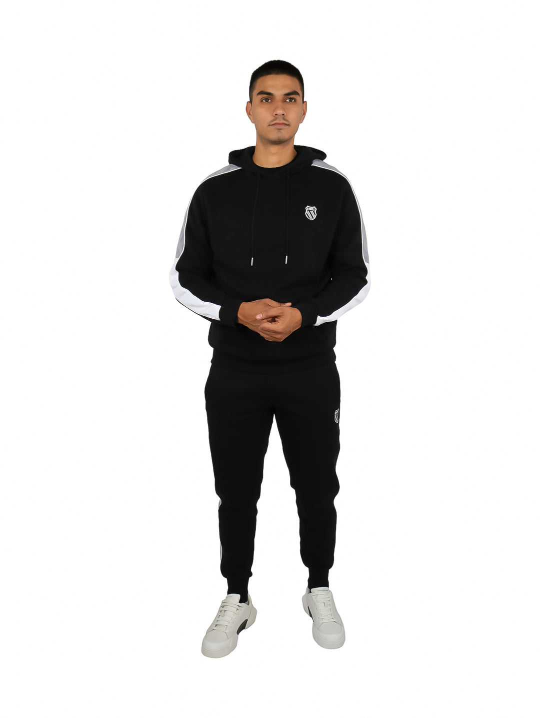 Hombre vistiendo un conjunto deportivo negro de K-Swiss compuesto por sudadera con capucha y pantalón.