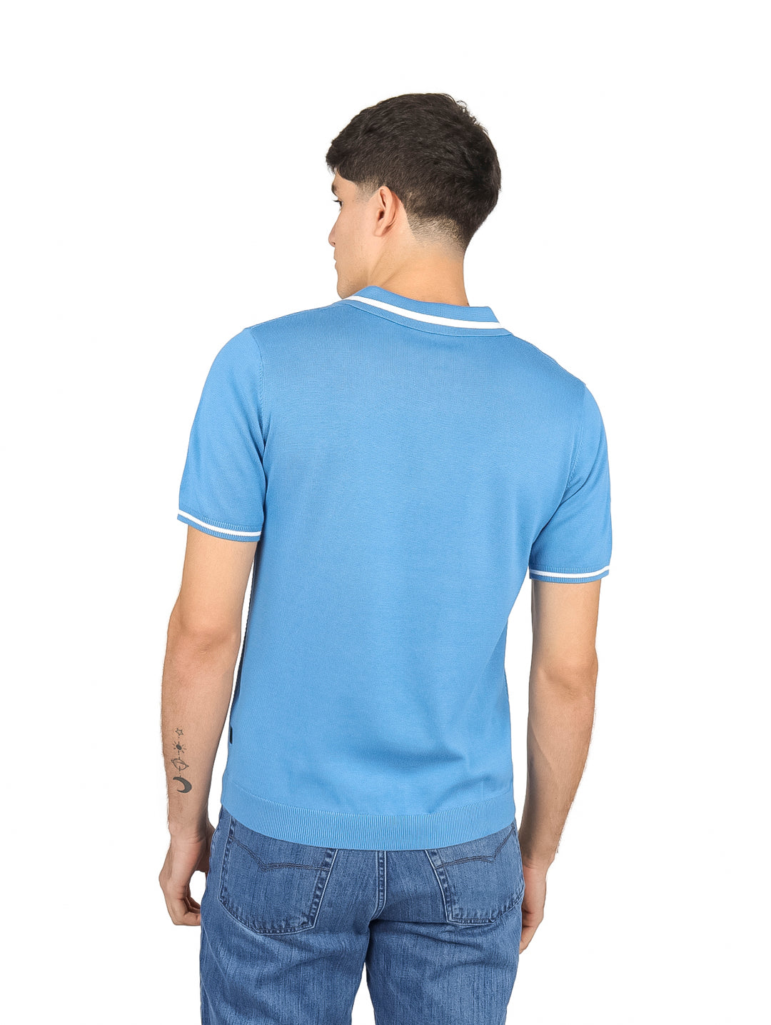 Hombre vistiendo una playera polo color azul claro con ribetes blancos en el cuello y las mangas.