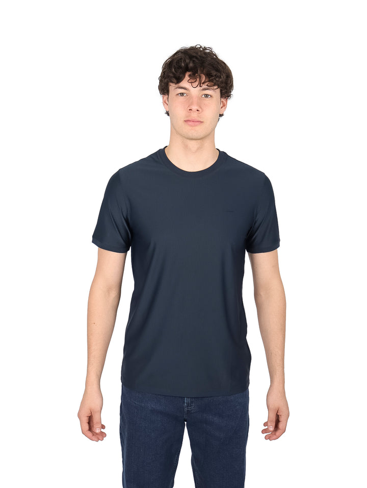 Hombre vistiendo una playera de manga corta color azul marino con cuello redondo.