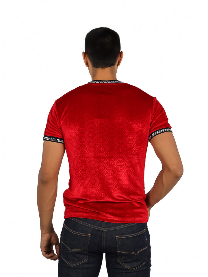 Hombre vistiendo playera roja de manga corta con detalles decorativos en cuello y mangas.