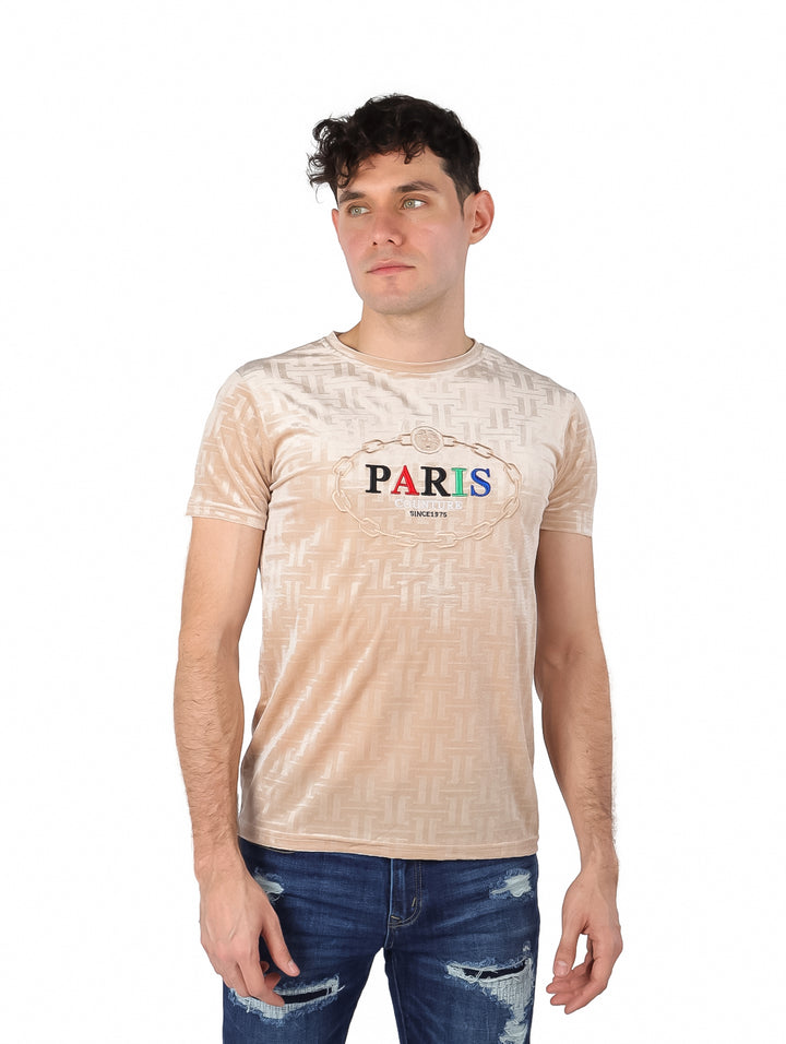 Hombre vistiendo playera manga corta color khaki con estampado geométrico y texto PARIS en el pecho.