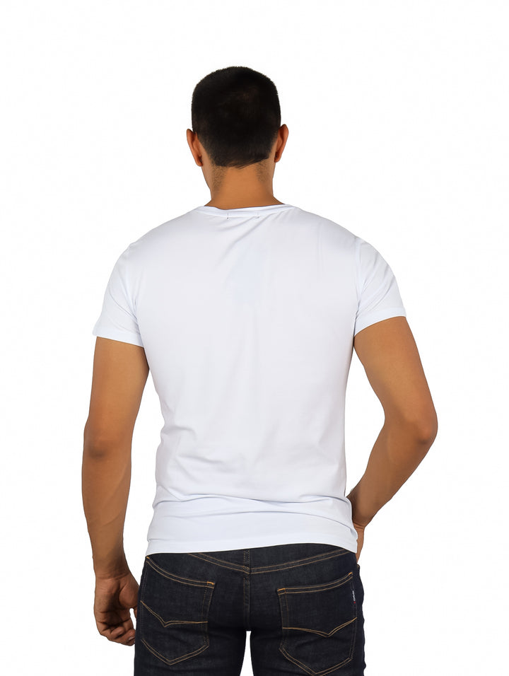 Hombre vistiendo playera blanca de manga corta con estampado gráfico de una calavera en el pecho.