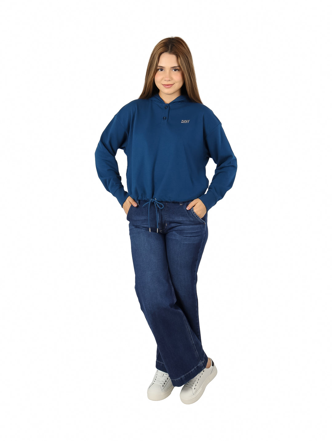 Mujer vistiendo una sudadera azul DKNY con capucha y pantalones de mezclilla.