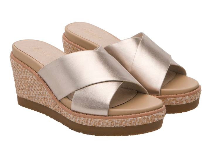 Sandalia de cuña color oro con plataforma tejida en beige y suela marrón.