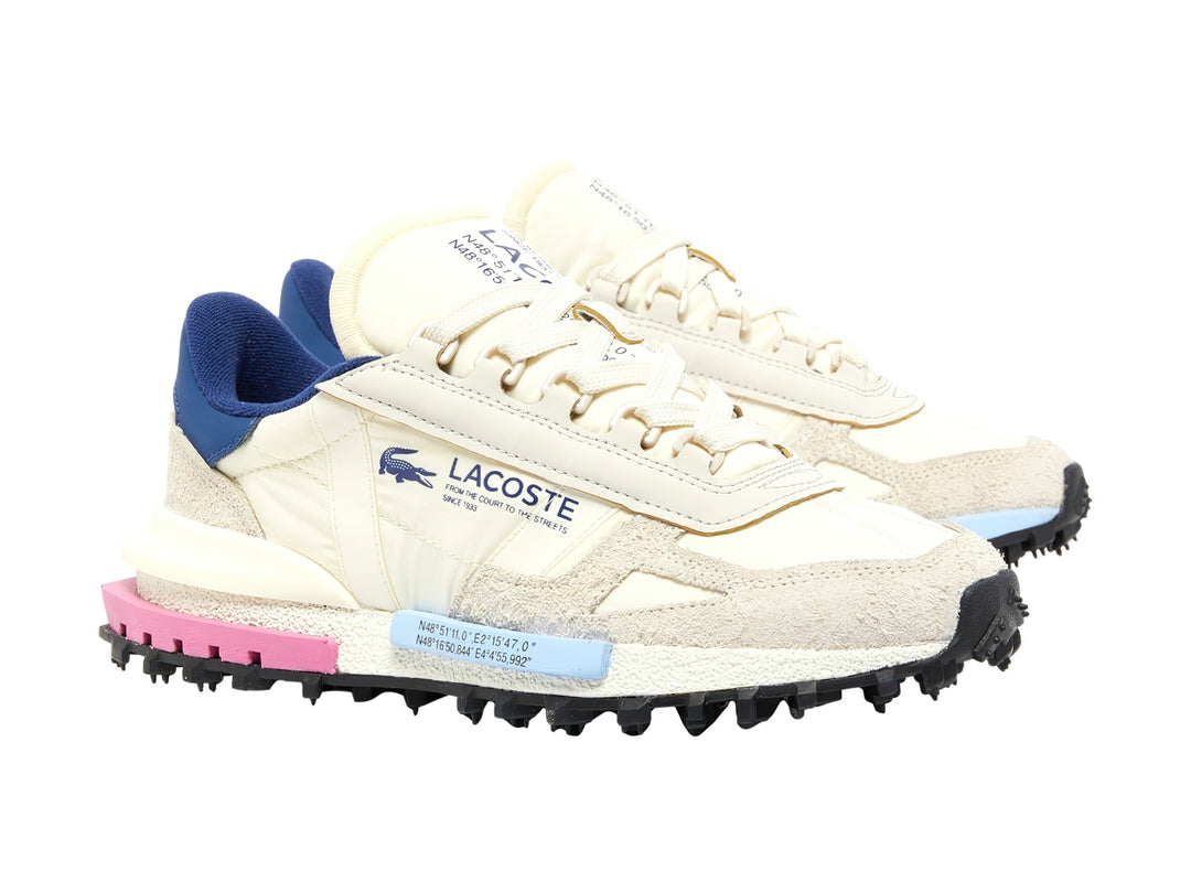 Tenis Lacoste color blanco con detalles en azul, rosa y celeste, suela negra dentada y logotipo lateral.