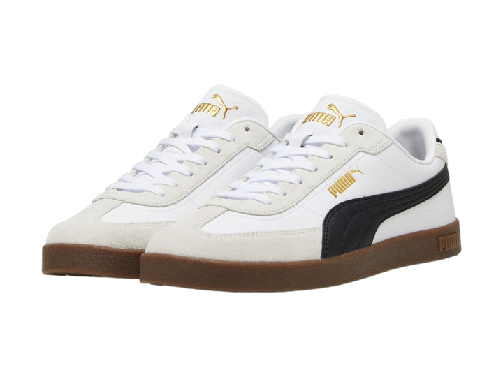 Tenis PUMA blancos con franja negra, punta gris y suela color caramelo.