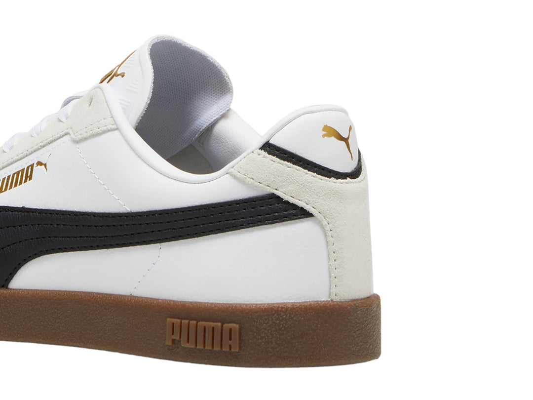 Tenis PUMA blancos con franja negra, punta gris y suela color caramelo.