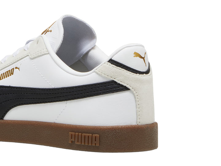 Tenis PUMA blancos con franja negra, punta gris y suela color caramelo.