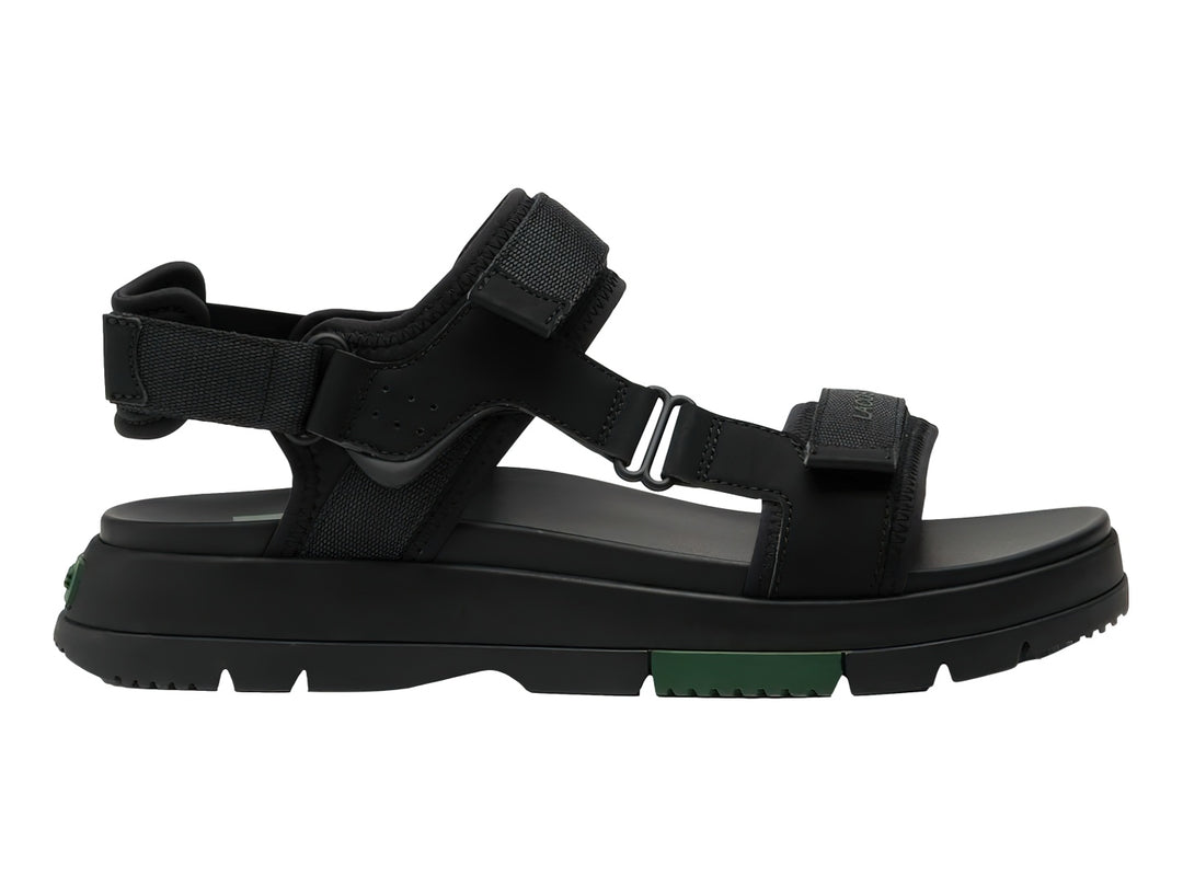 Sandalia negra Lacoste Suruga PRM con suela de plataforma y detalles en verde oscuro.