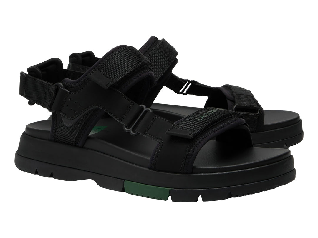 Sandalia negra Lacoste Suruga PRM con suela de plataforma y detalles en verde oscuro.