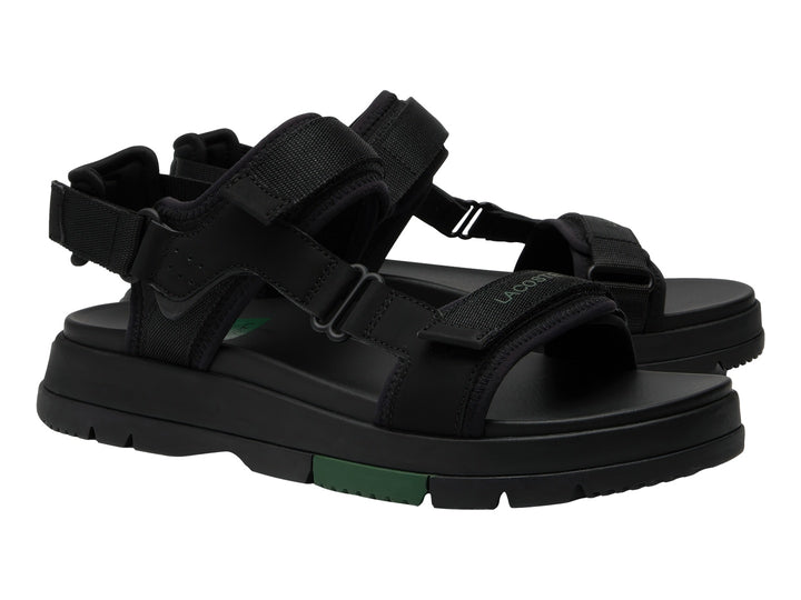 Sandalia negra Lacoste Suruga PRM con suela de plataforma y detalles en verde oscuro.