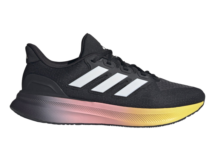 Tenis deportivos Adidas color negro con suela en degradado de rosa a amarillo y franjas blancas laterales.