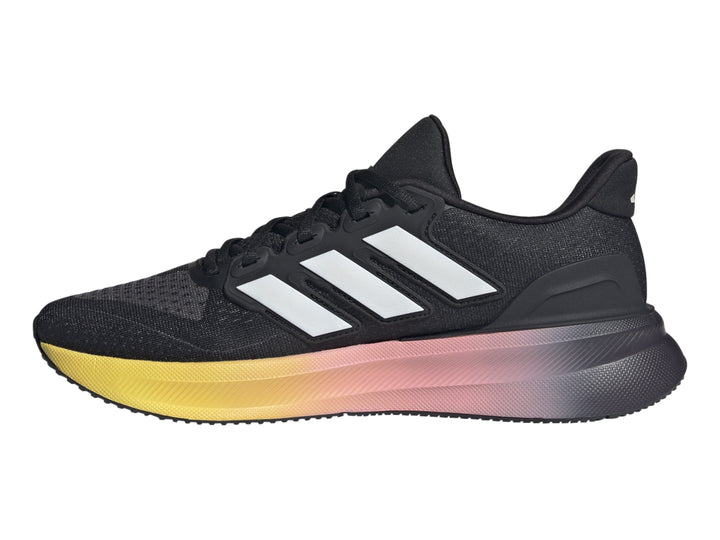 Tenis deportivos Adidas color negro con suela en degradado de rosa a amarillo y franjas blancas laterales.
