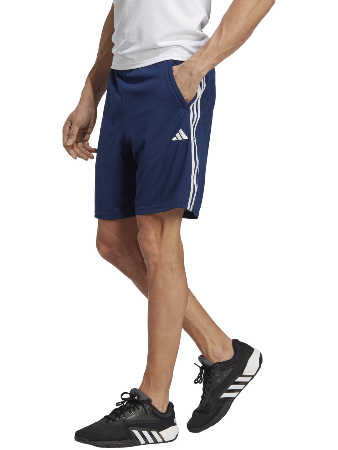 Hombre usando shorts deportivos Adidas azul oscuro con franjas blancas laterales.