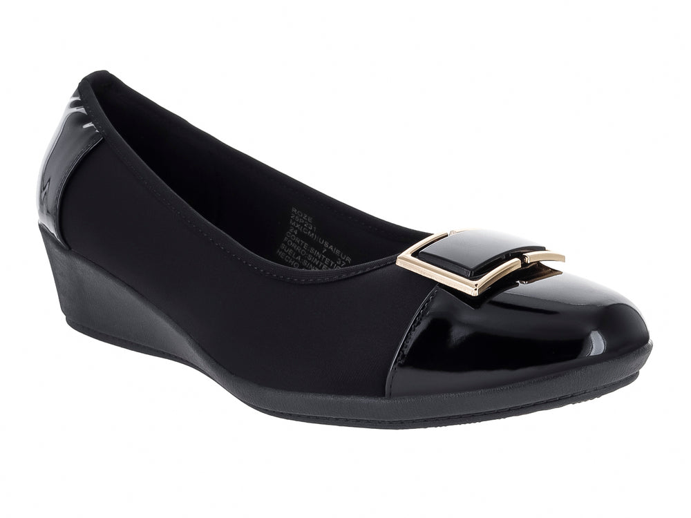 Zapato de cuña color negro para mujer con detalle de hebilla dorada y acabado en charol y tela.
