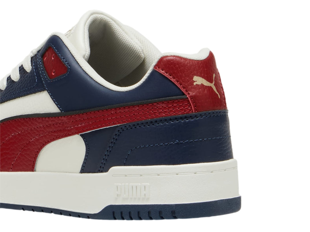 Tenis PUMA RBD Game Low en colores azul marino, rojo y blanco con suela blanca.