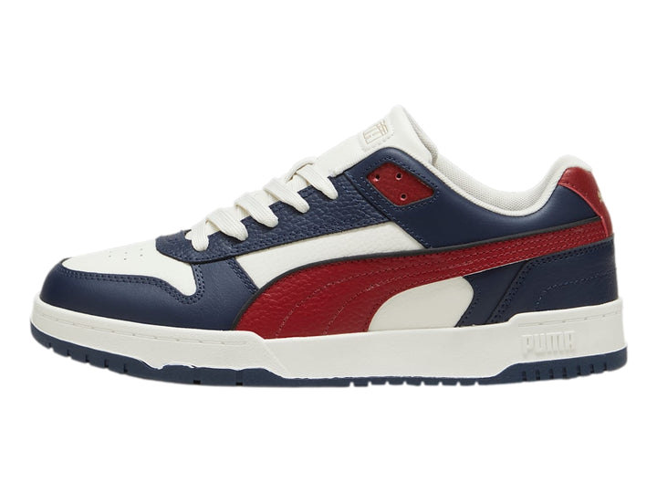Tenis PUMA RBD Game Low en colores azul marino, rojo y blanco con suela blanca.