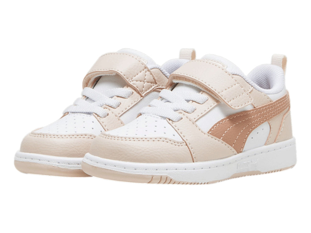 Tenis PUMA Rebound V6 Lo AC+ Infant en color blanco con detalles en rosa pastel y cierre de velcro.