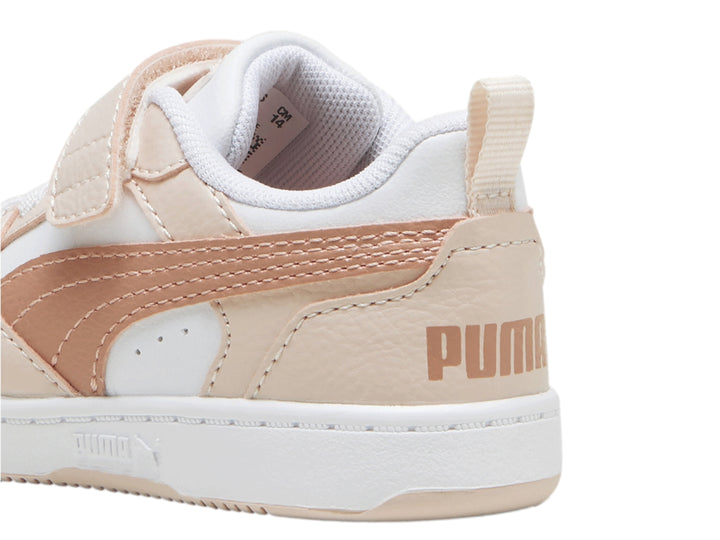 Tenis PUMA Rebound V6 Lo AC+ Infant en color blanco con detalles en rosa pastel y cierre de velcro.