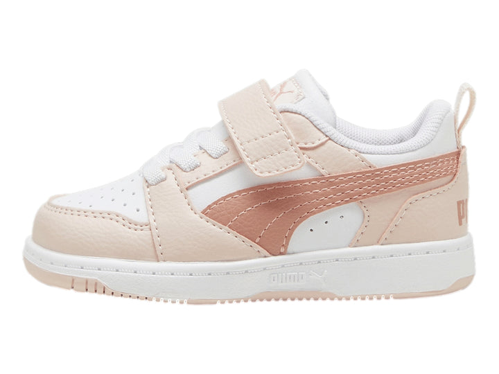 Tenis PUMA Rebound V6 Lo AC+ Infant en color blanco con detalles en rosa pastel y cierre de velcro.