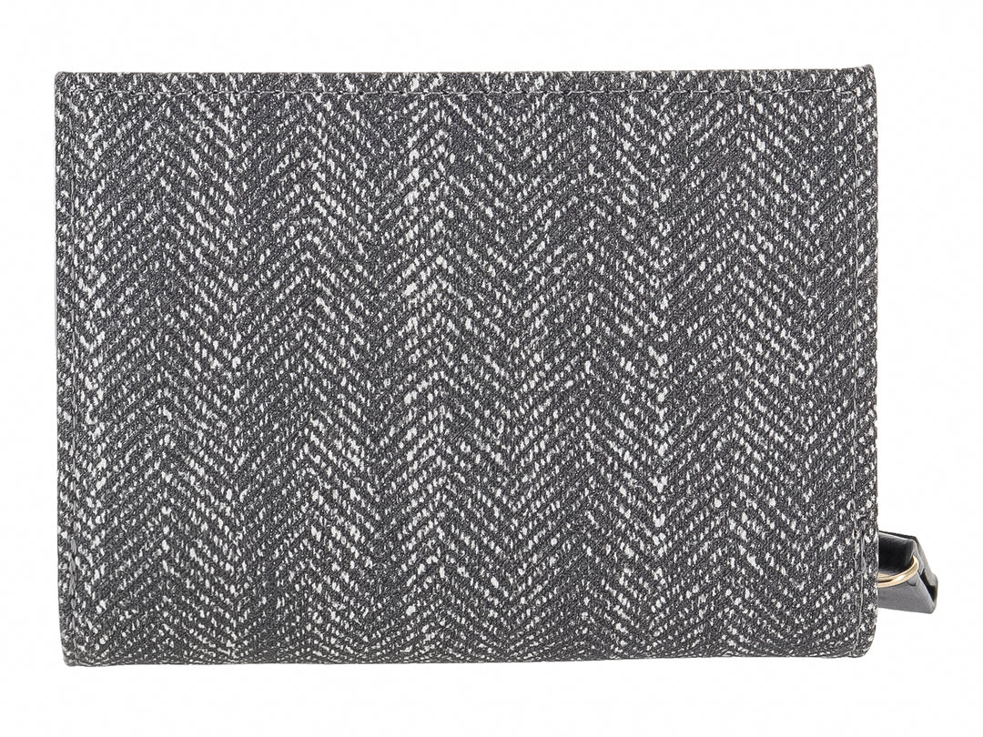 Monedero rectangular de tela con estampado de espiga en colores negro y gris y placa metálica central.
