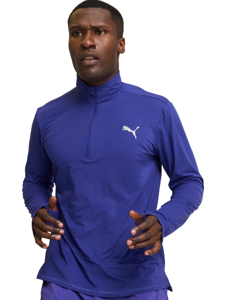 Hombre vistiendo camiseta deportiva PUMA azul lapis lazuli de manga larga con cierre de un cuarto.