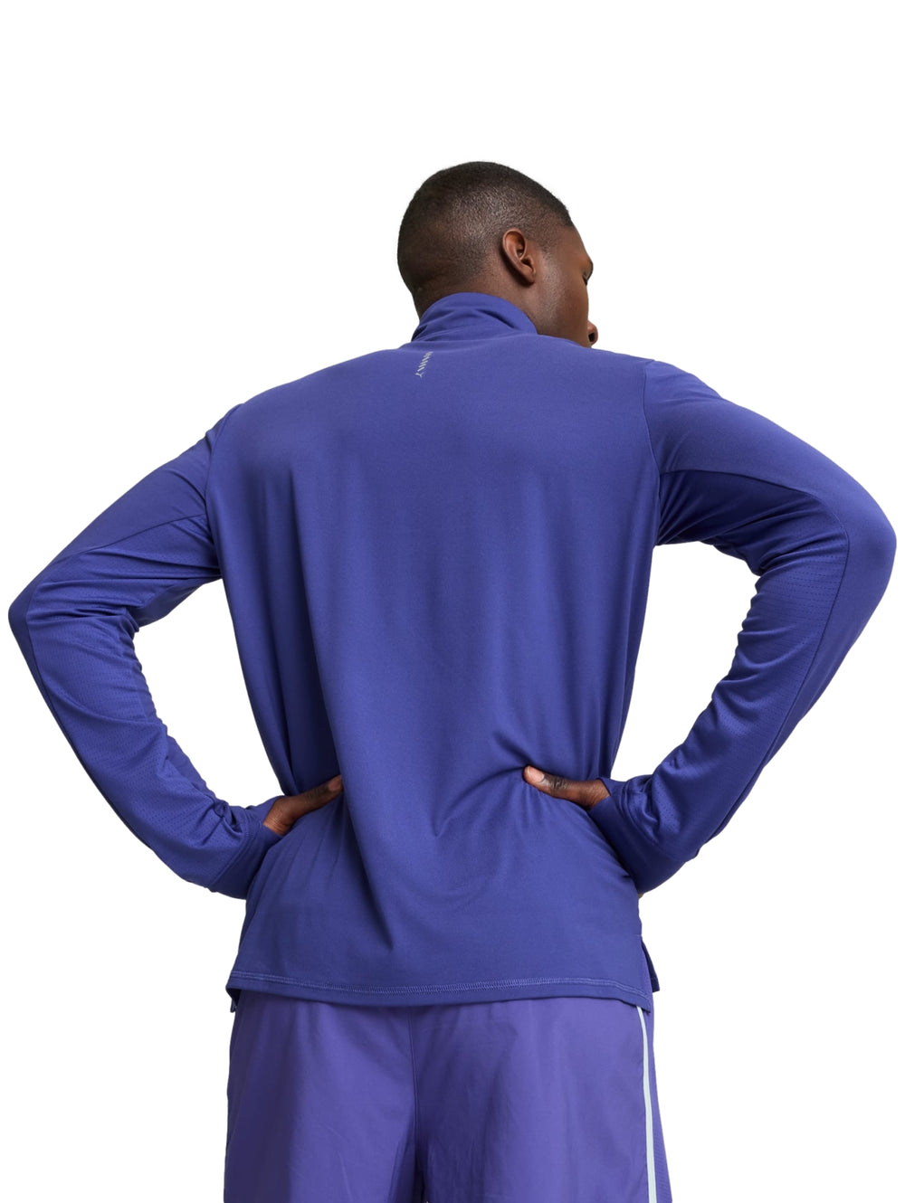 Hombre vistiendo camiseta deportiva PUMA azul lapis lazuli de manga larga con cierre de un cuarto.