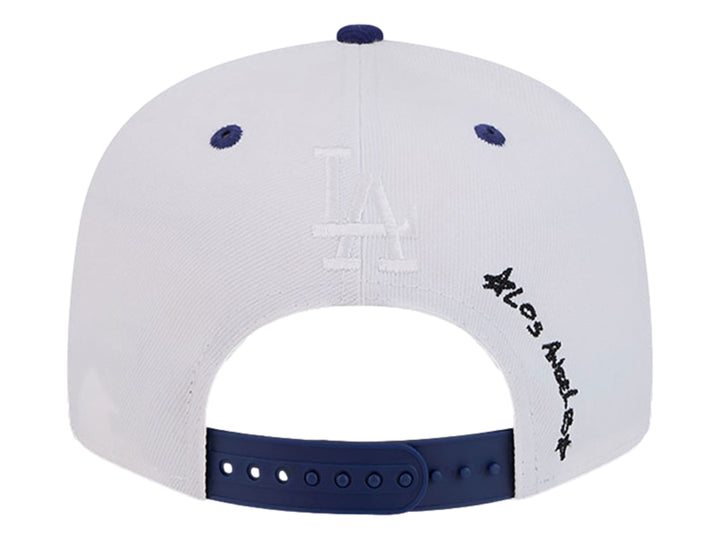 Gorra New Era blanca con visera azul y logotipo de los LA Dodgers estilo doodle.