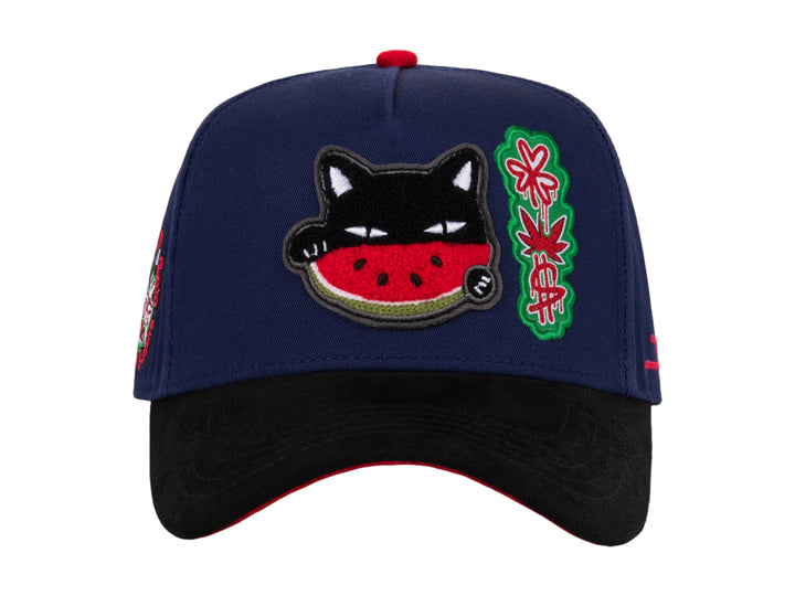 Gorra snapback azul con visera negra y parches decorativos de gato sandía y diseño floral.