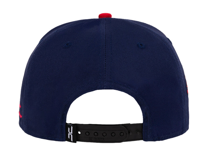 Gorra snapback azul con visera negra y parches decorativos de gato sandía y diseño floral.