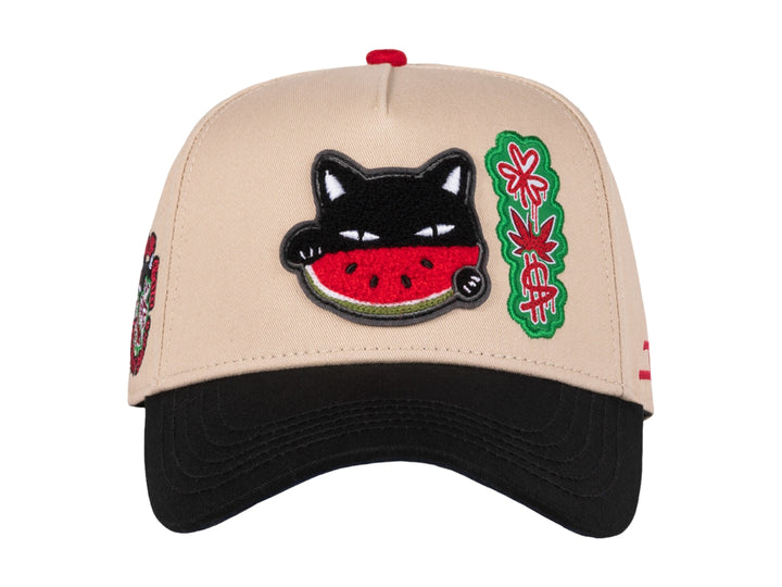 Gorra snapback color beige con visera negra, decorada con un parche de gato comiendo sandía y detalles en rojo.