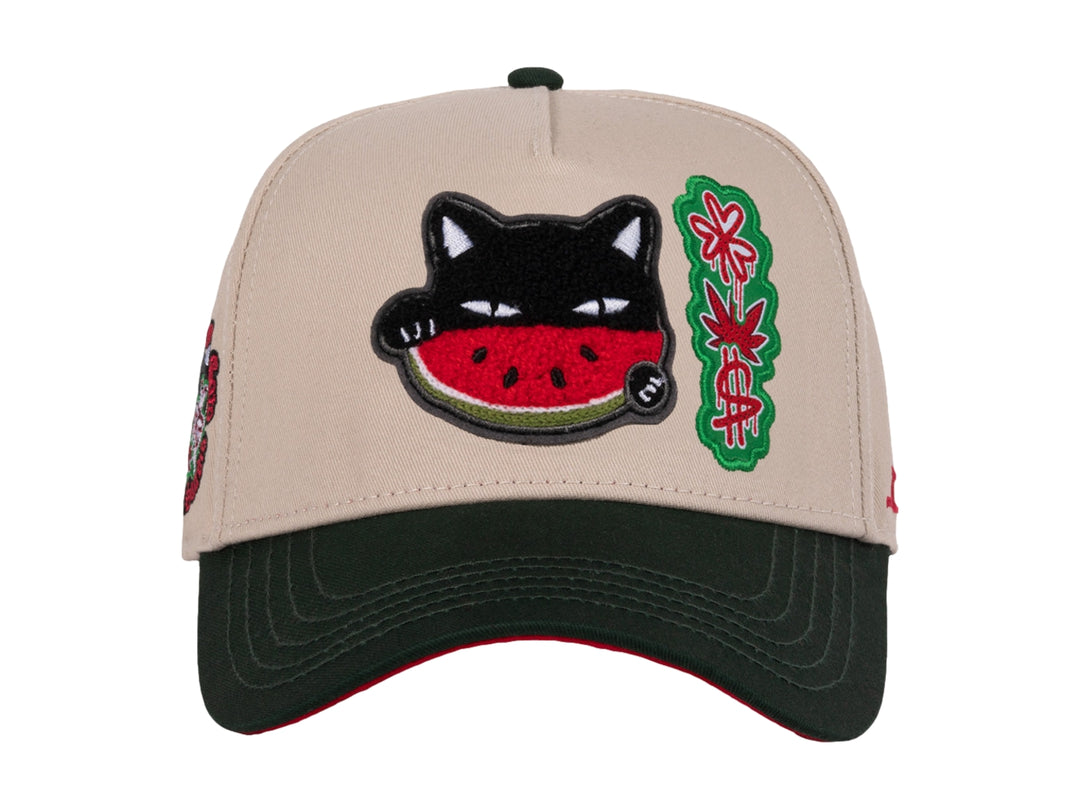 Gorra snapback color beige con visera verde y un parche bordado de un gato comiendo sandía en el frente.