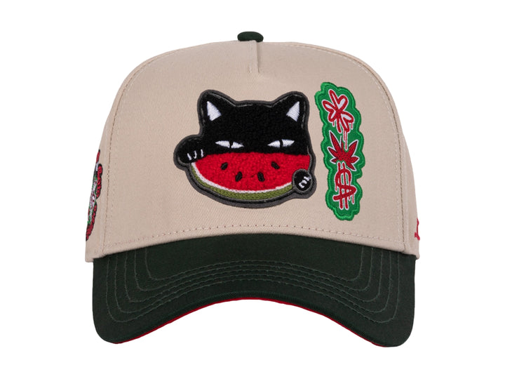 Gorra snapback color beige con visera verde y un parche bordado de un gato comiendo sandía en el frente.
