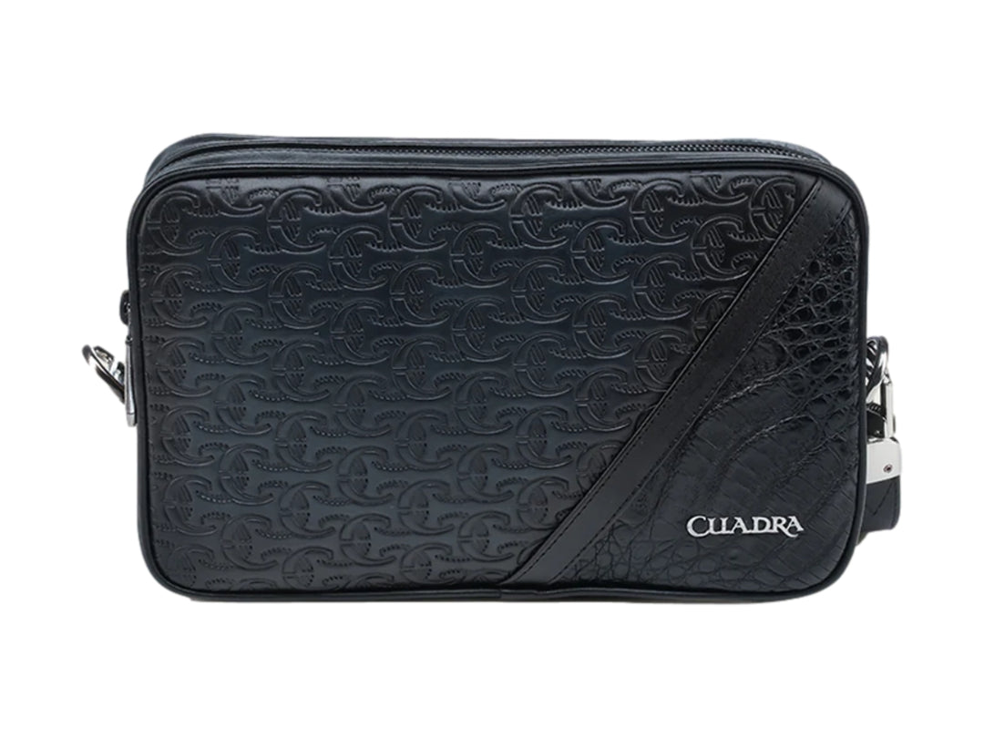 Bolso estilo cartera Cuadra en cuero negro con textura grabada y detalle de piel exótica en el lateral.