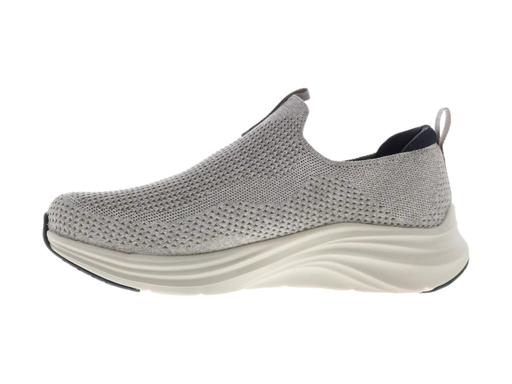 Zapato deportivo Skechers color natural con suela blanca y detalles en negro, diseño sin cordones.