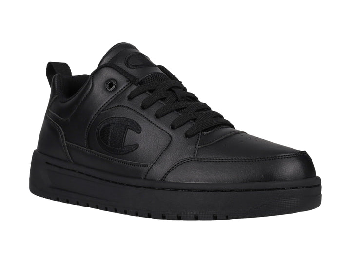 Tenis Champion color negro, diseño de corte bajo con suela gruesa y logo en el lateral.