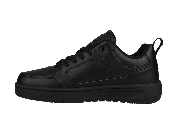 Tenis Champion color negro, diseño de corte bajo con suela gruesa y logo en el lateral.