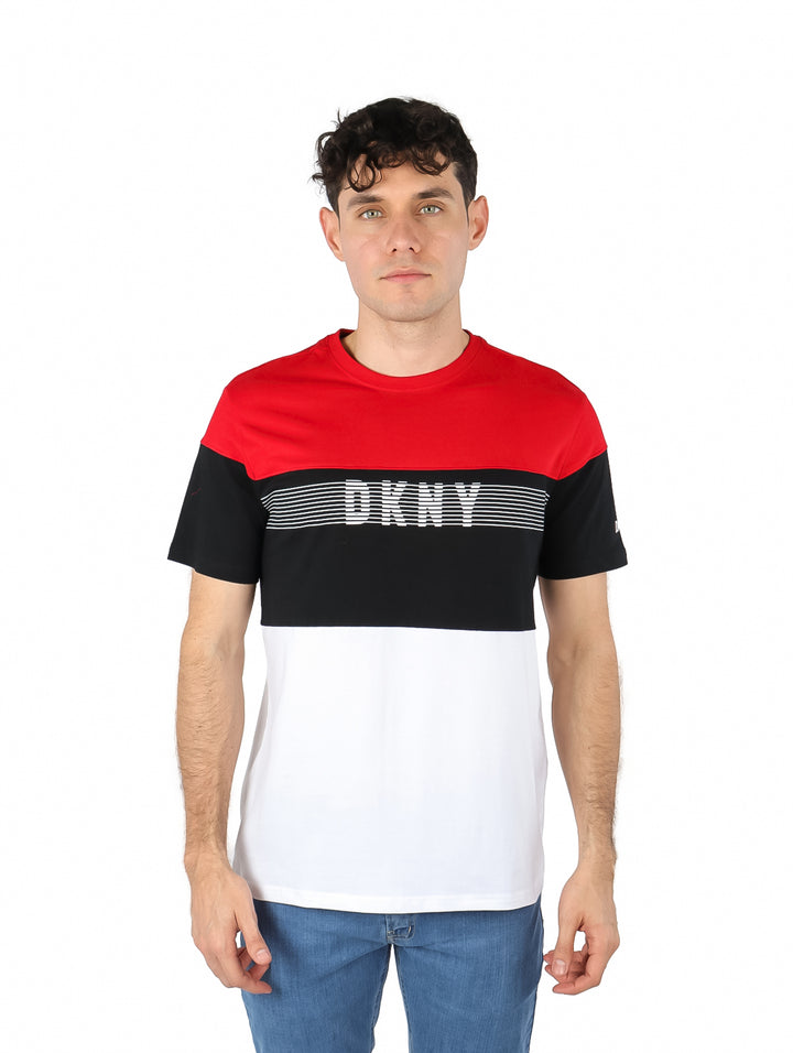 Hombre vistiendo playera DKNY de manga corta con bloques de color rojo, negro y blanco.
