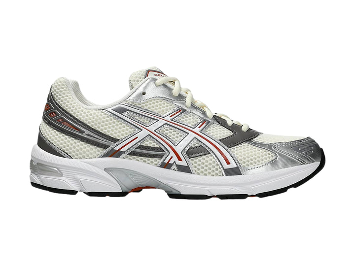 Tenis ASICS GEL-1130 en color crema y blanco con detalles en gris y rojo, vista lateral.